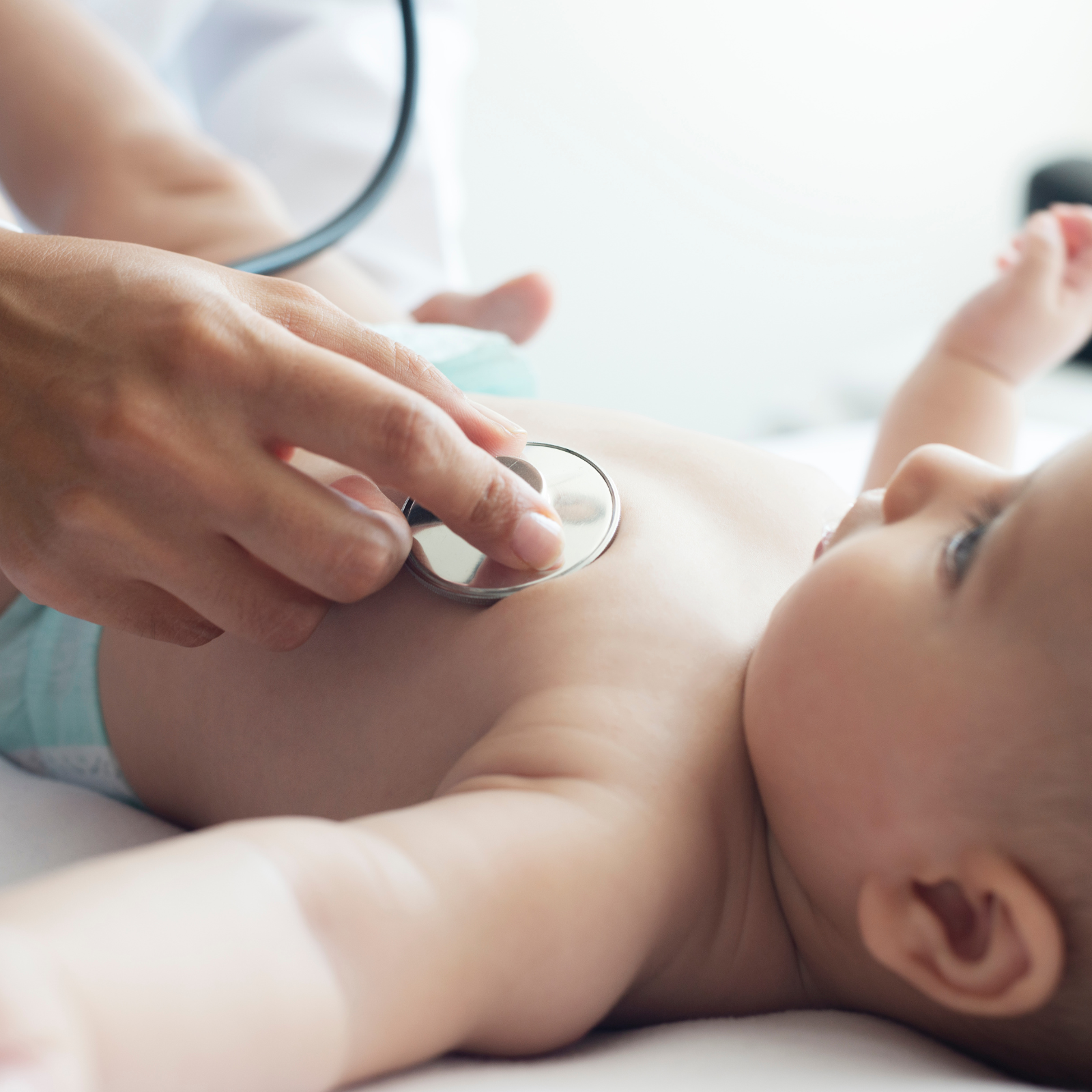 Pediatrician checking the heartbeat of a baby