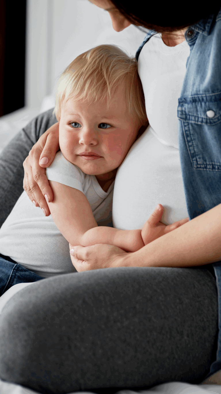 Toddler cuddling with his pregnant mom