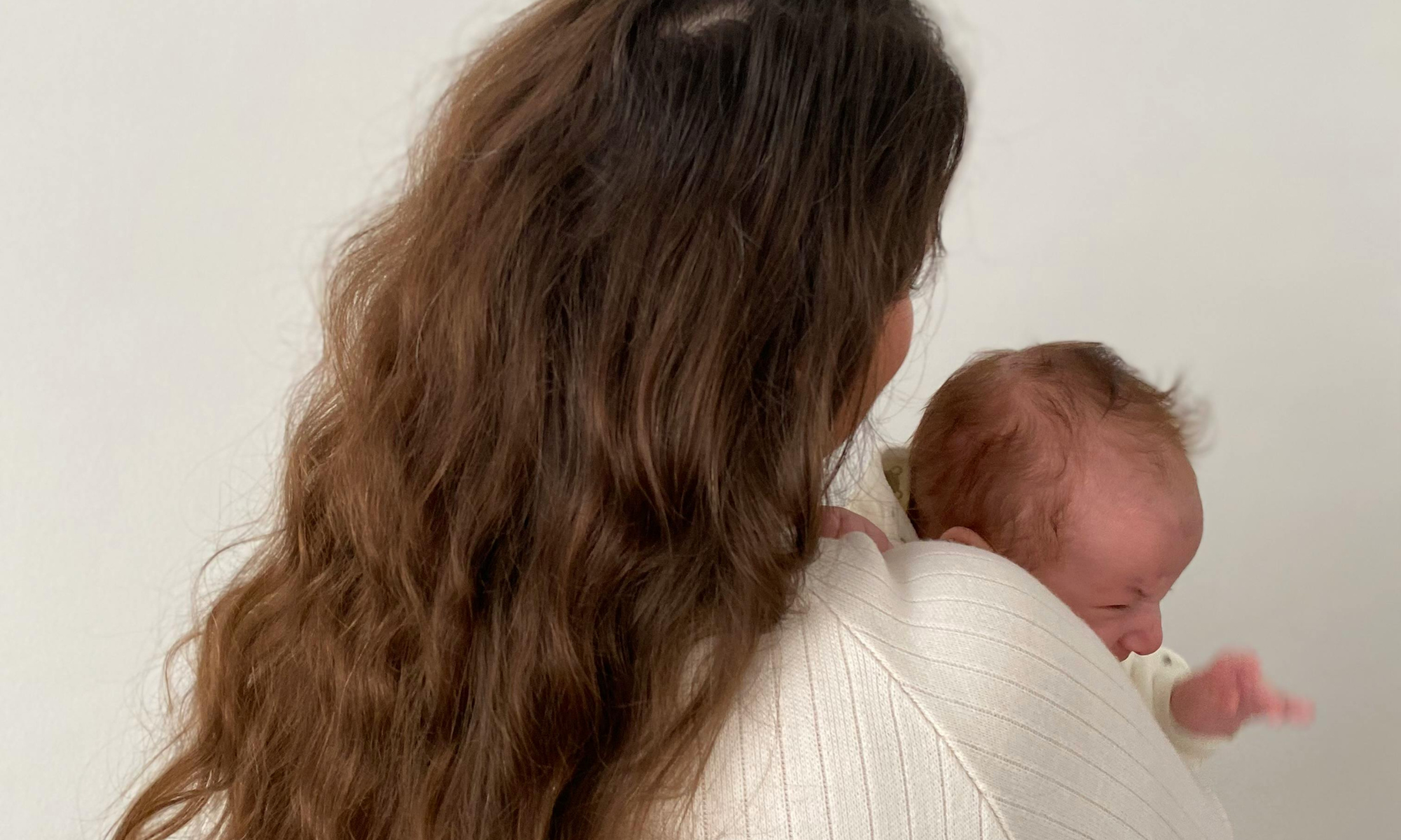 Mom holding a newborn in early postpartum