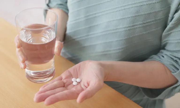 woman holds abortion pills as if she will take them