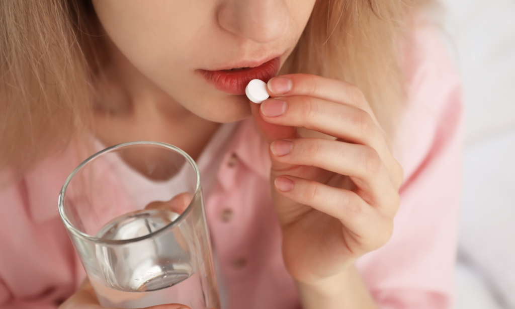 girl taking a white pill representing the morning after pill
